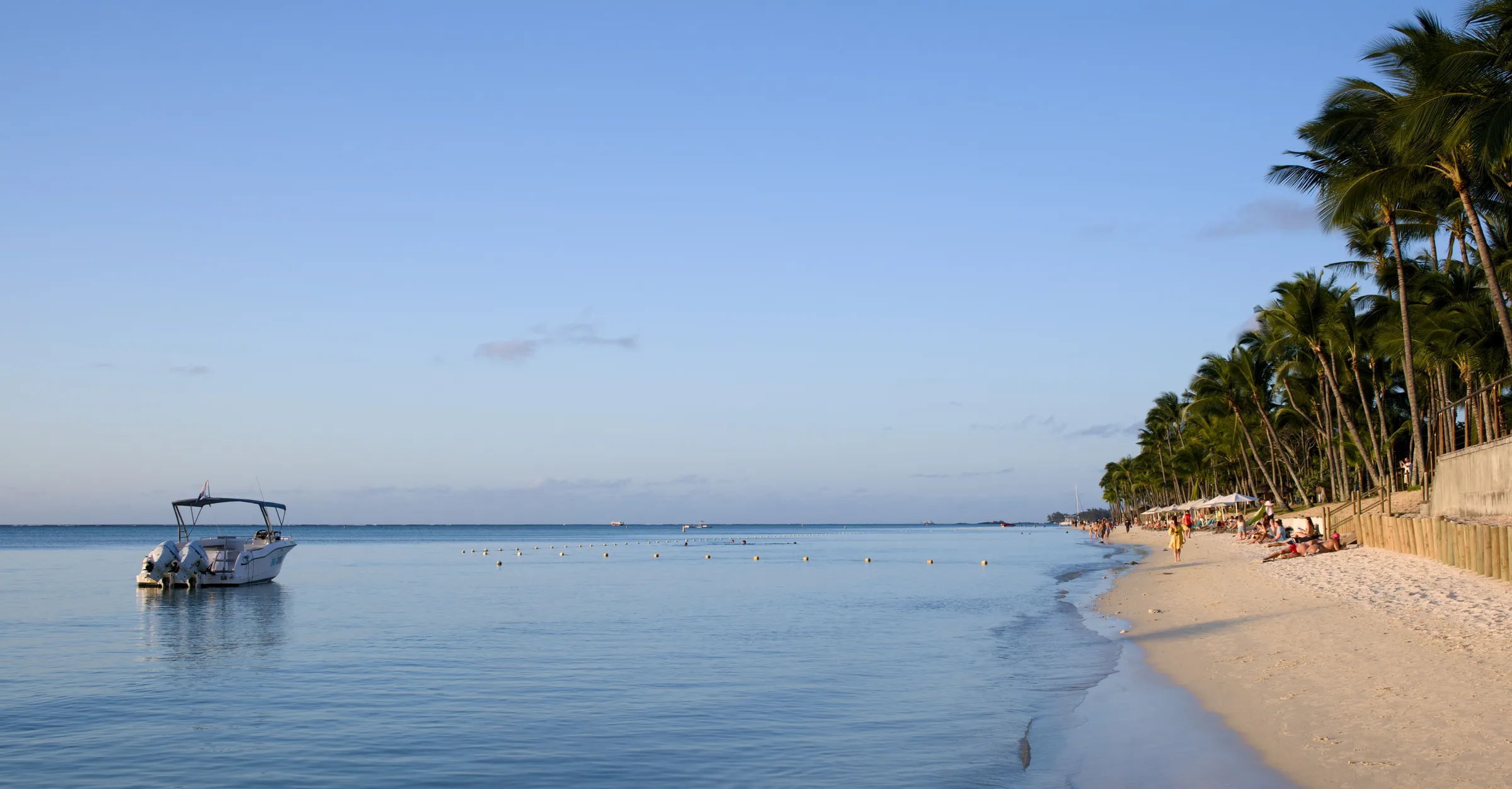 White sand beach lined with palm trees and turquoise water, Mauritius